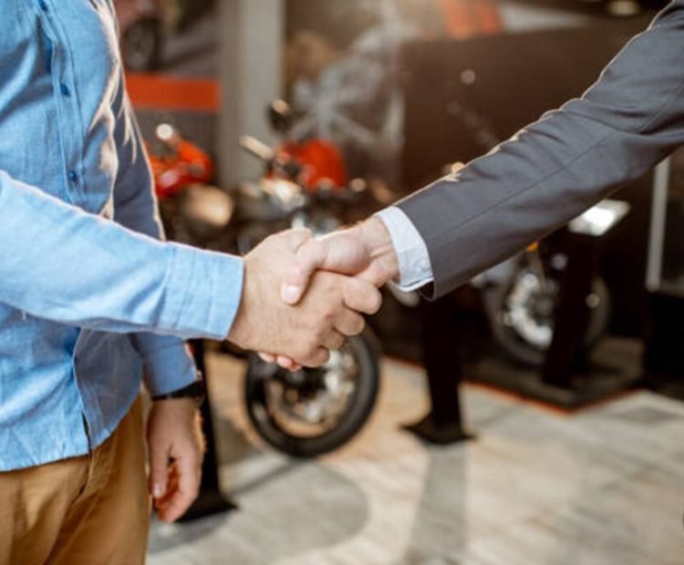 Handshake between two people in a motorcycle showroom